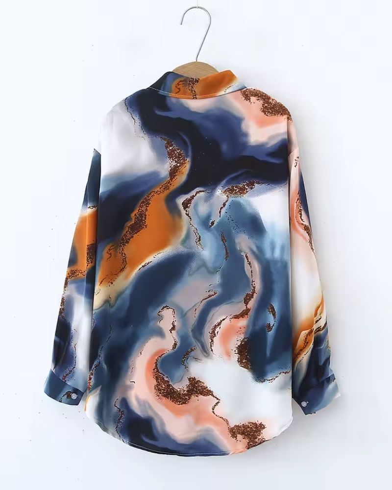 Colorful patterned shirt on a hanger against a white background