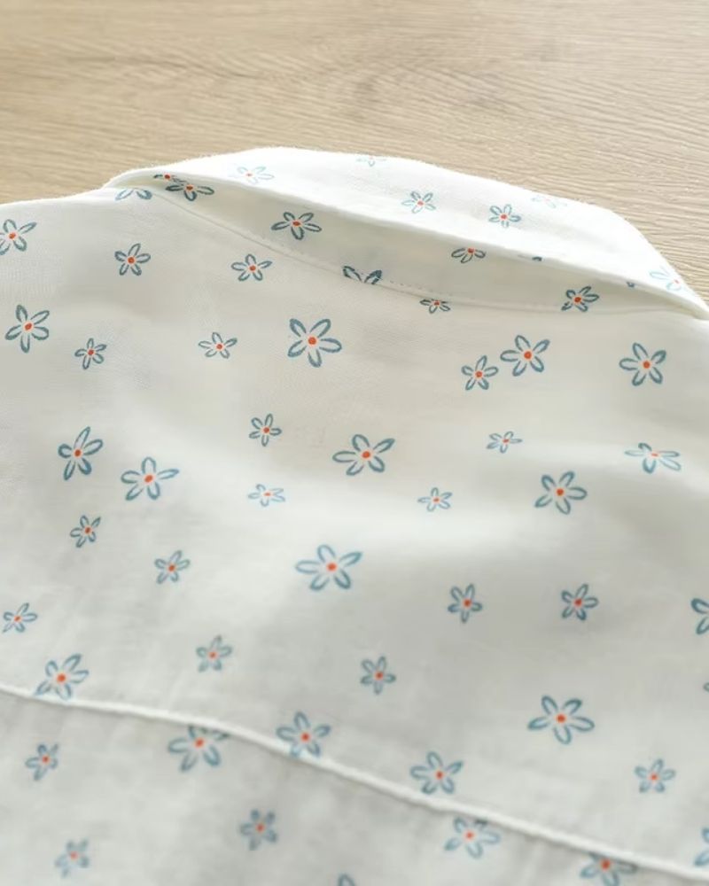 Back view of Celeste Bloom rayon shirt for women featuring delicate blue floral pattern on breathable off-white fabric

