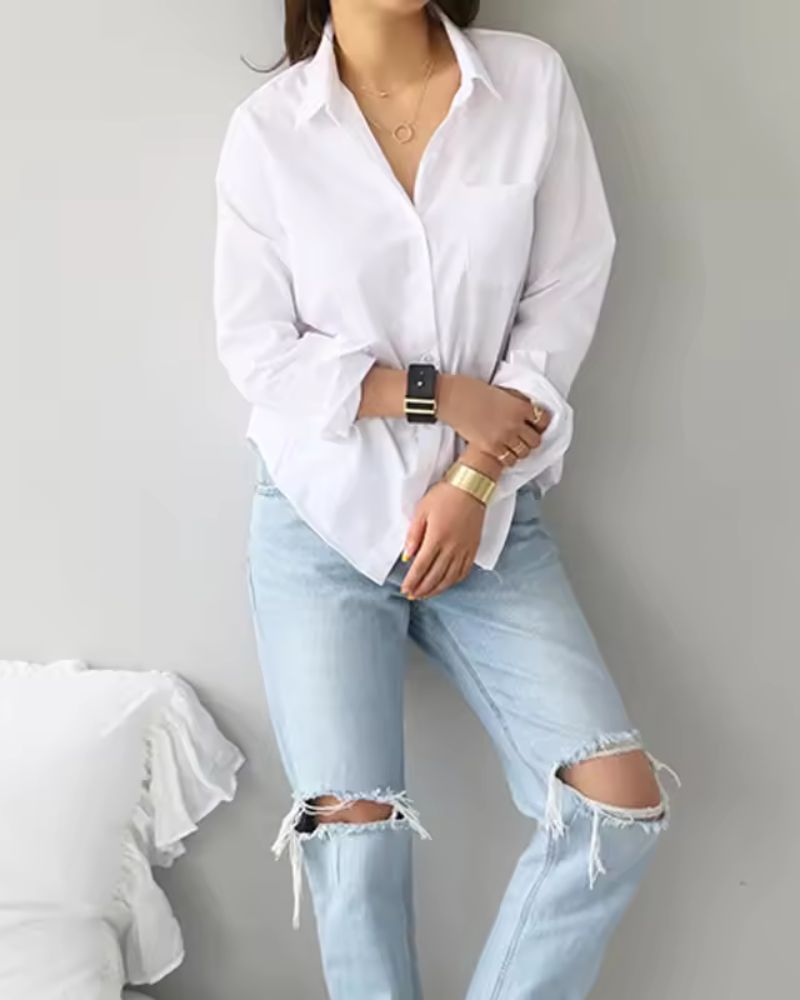 Classic white button-down shirt paired with light denim jeans and gold accessories

