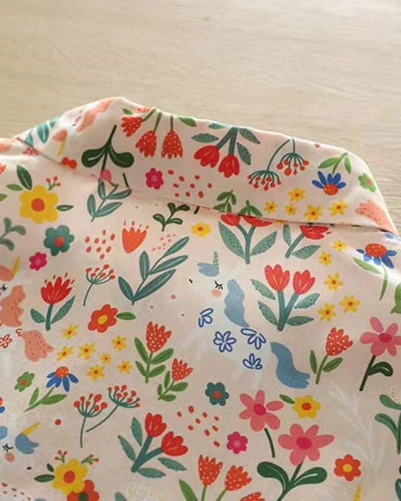 Detailed close-up of whimsical floral and unicorn design on La Lune Botanique shirt fabric

