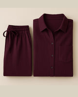 “Flat lay of burgundy crinkle cotton lounge set with button-up shirt and drawstring pants”

