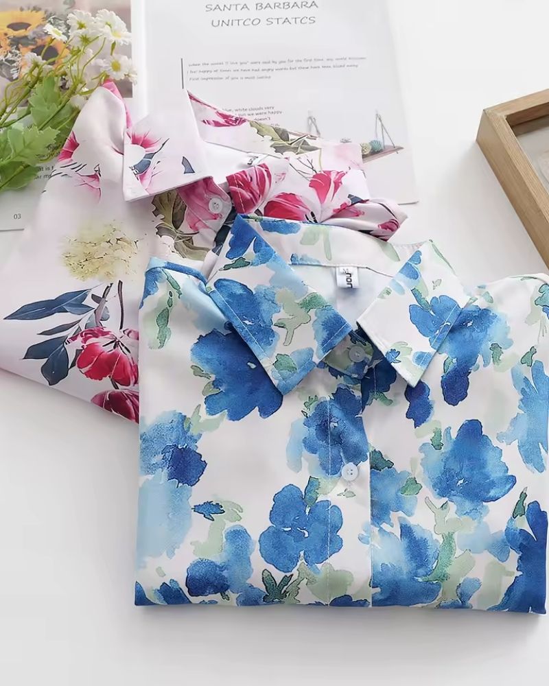 Folded women’s rayon shirt featuring a blue watercolor floral print on a white base