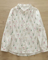 Front view of floral rayon shirt for women in ivory with pink and yellow botanical prints, buttoned up and laid flat

