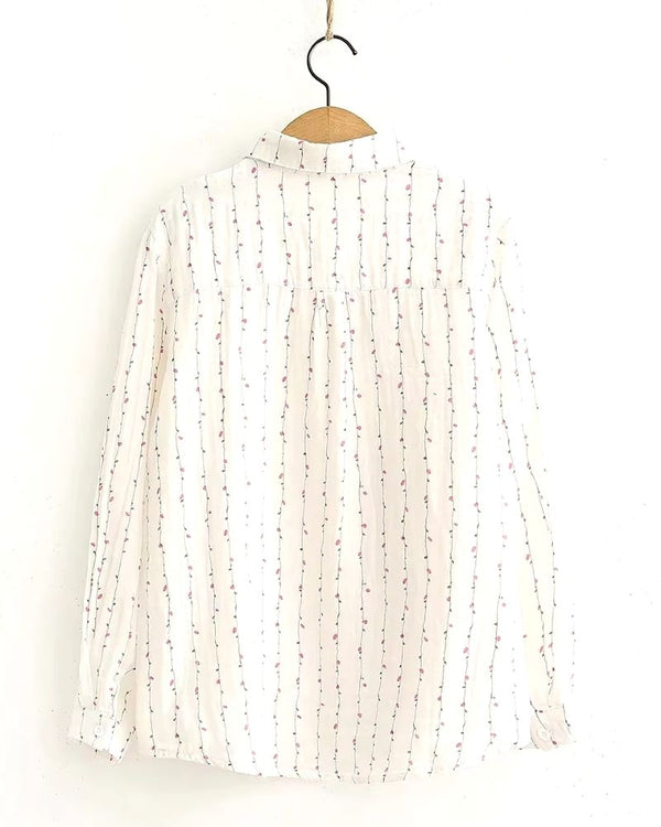 Front view of white rayon blouse with vertical pink vine print, long sleeves and collar

