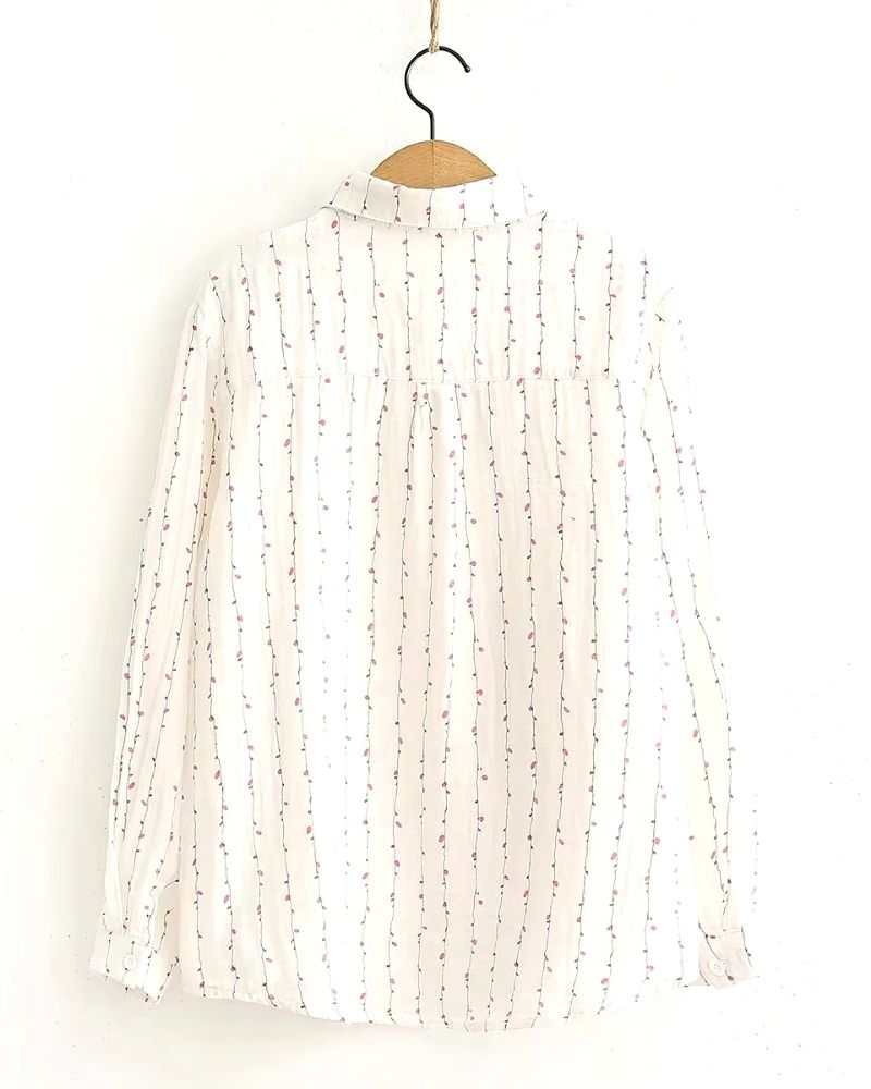 Front view of white rayon blouse with vertical pink vine print, long sleeves and collar

