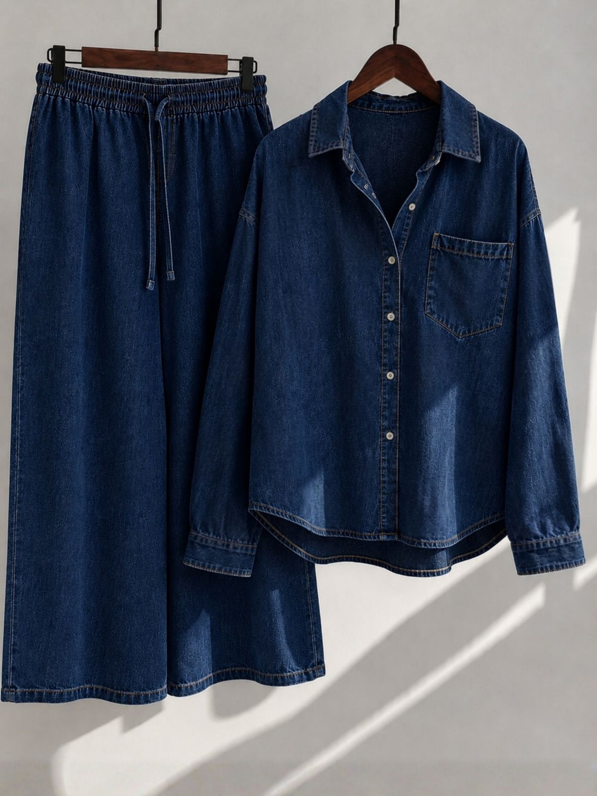 Indira Dark Indigo denim shirt and wide-leg palazzo displayed on wooden hangers