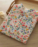 La Lune Botanique shirt folded neatly, displaying collar and vibrant garden-themed pattern on rayon fabric

