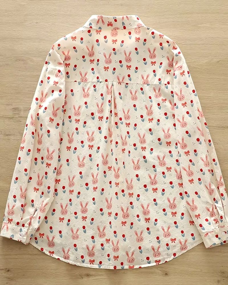 Lightweight women’s blouse with pink bunny, tulip, and bow print on white background

