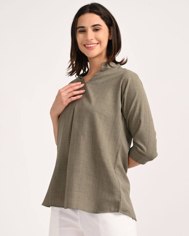 Side view of olive green linen blend short kurta styled with white wide-leg pants