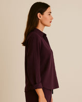 “Side view of relaxed fit crinkle cotton shirt in burgundy with cuffed sleeves”

