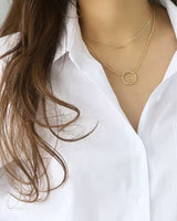 Soft white rayon shirt collar detail with gold circle pendant layered necklace

