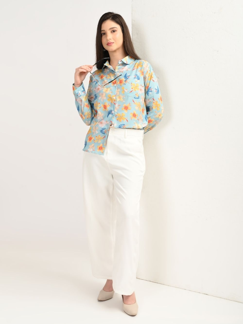 Woman in aqua blue floral shirt and white trousers, full look