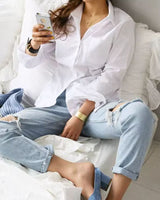 Woman lounging in premium white rayon shirt with distressed jeans and heels

