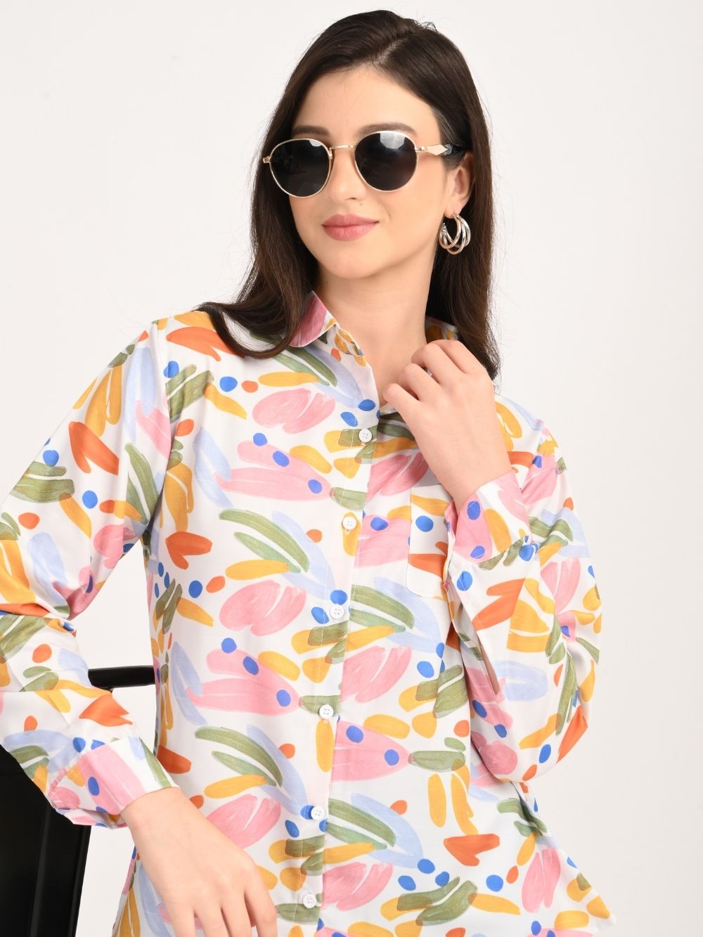 Woman smiling in abstract print shirt with vibrant brushstrokes