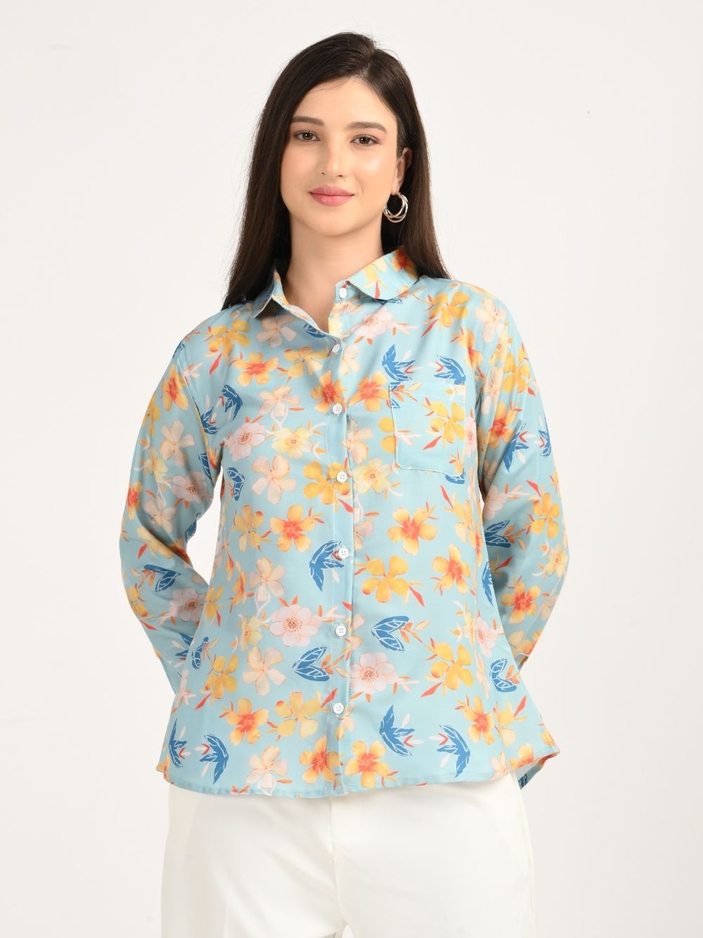 Woman smiling in aqua blue floral print shirt, front view