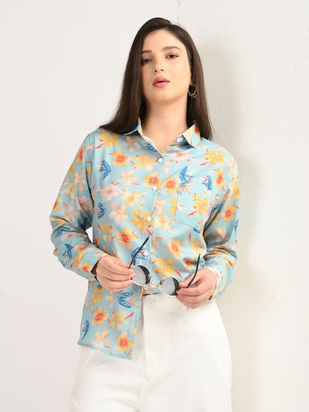 Woman wearing aqua blue floral print shirt, front view