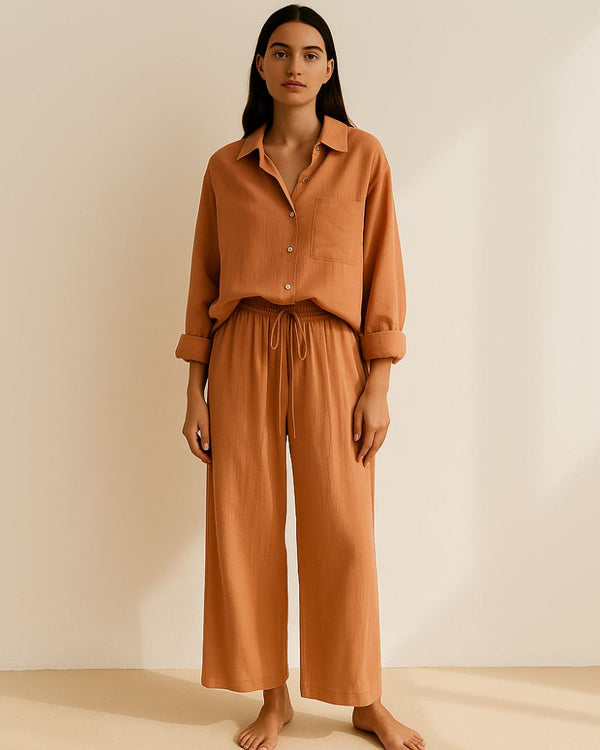 Woman wearing terracotta muslin lounge set with button-down shirt and drawstring trousers

